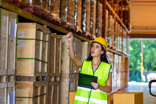 Caucasian woman warehouse worker employee working and checking inventory stock on parcel shelf in distribution fulfillment center. Business industry and freight transportation logistic cargo concept.