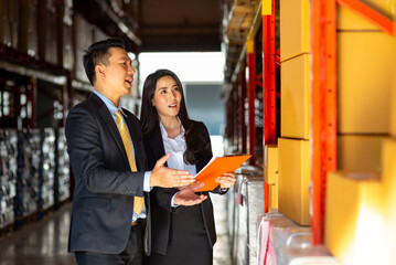 Asian businessman and businesswoman warehouse manager meeting and discussion during working in distribution fulfillment center. Business industry, Freight transportation and logistic cargo concept.