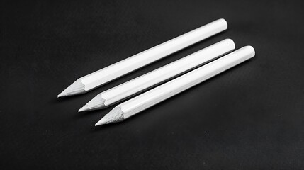 White pencils on a black background. Close-up.