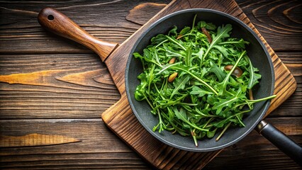 High angle view of preparing wilted arugula salad as a side dish for steak in frying pan