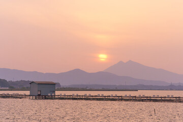 霞がかった霞ヶ浦から望む夕暮れ時の筑波山ののどかな風景