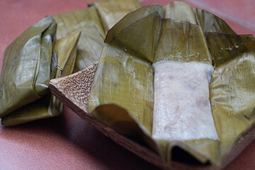 Traditional Thai banana cake. Wrapped in banana leaves. Steamed until cooked and delicious.Placed on a plate made from coconut palm.