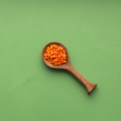 Lens culinaris - Spoon with raw red lentils.