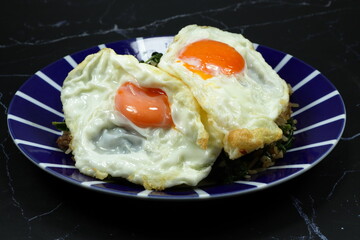 Fried spicy minced pork rice topping with fresh and organic chicken egg yolk serving on the plate. Famous special street food menu in Asia. 