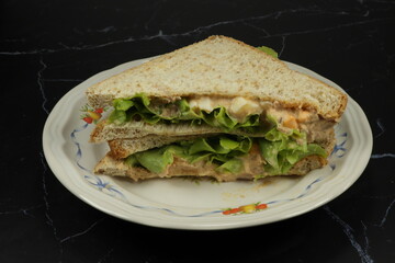 Pile of fresh and organic tuna and egg sandwich serving in the plate. Famous quick and easy breakfast menu in Asia. 