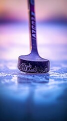 Close-up of a hockey stick and puck on frozen ice surface