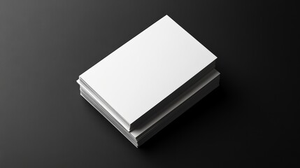 Fototapeta premium A stack of blank white business cards isolated on a black background.