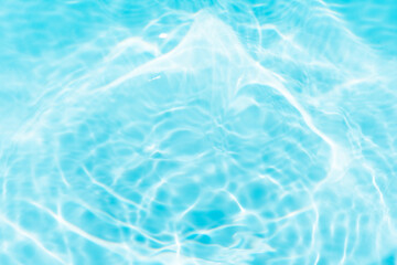 Blue water with ripples on the surface. Defocus blurred transparent blue colored clear calm water surface texture with splashes and bubbles. Water waves with shining pattern texture background.