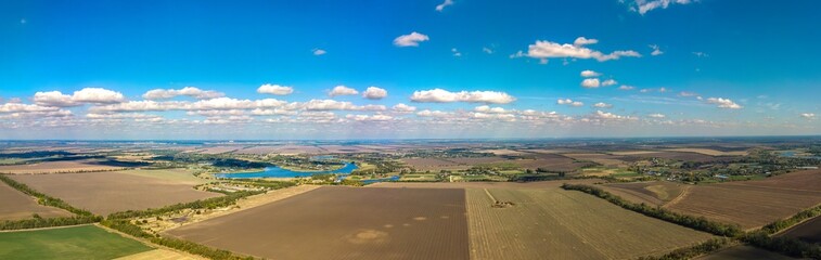 aerial panorama view of ponds and village Nekrasovskoye surrounded by autumn fields (South of Russia, Kuban) on a sunny day in October