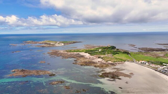 Guernsey. Flight towards Lihou Island on west coast of Island at half tide showing causeway and the crystal clear waters of this RAMSAR site on bright sunny day
