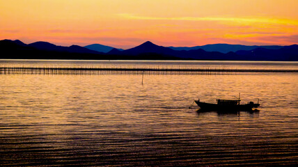 有明海の夕焼けと漁船。海苔養殖の風景