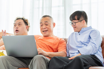 Cheerful grandfather and grandson using laptop doing a video call in living room, Senior asian man having a good time sitting on couch at home with adult son