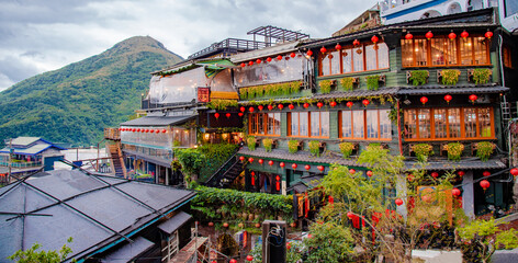 Obraz premium Jiufen Old Street is a narrow, winding alleyway with shops, teahouses, and restaurants that offers tourists a view of traditional Taiwanese life.
