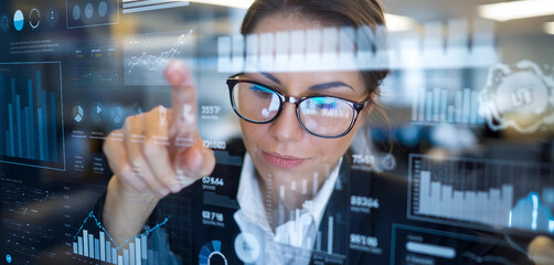 A woman in glasses working with advanced digital graphs and analytics on a transparent screen