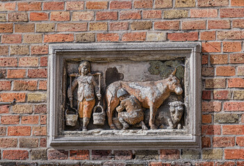 A wall bas relief in Huidenvettersplein (Tanners Square), representing milk production, in the historic centre of Bruges, Unesco World Heritage Site, Belgium, Europe