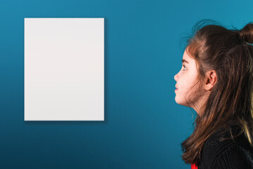 Young girl reads a wall ad. Mockup. A sheet of paper with space for text