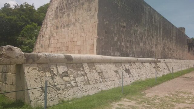 Gimbal wide panning shot of the serpentine statue above the bas-relief carvings at the Great Ball Court in Chichen Itza, Mexico. 4K