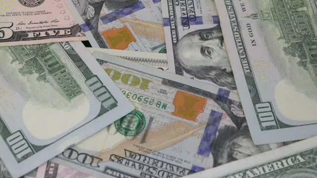 Moving background of chaotically scattered dollar bills, slow motion.