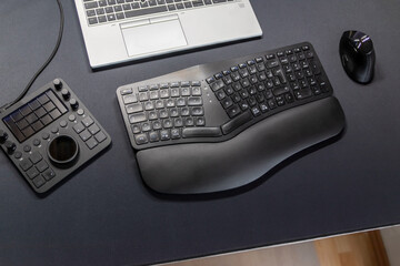 Ergonomic keyboard and ergonomic mouse as ergonomic home office equipment for freelance work and healthy workplace for notebook and clean desktop for efficient work from home for video editing graphic