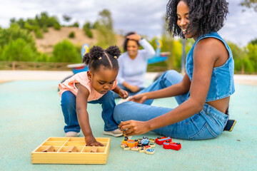 Little african girl messing with toys from a box