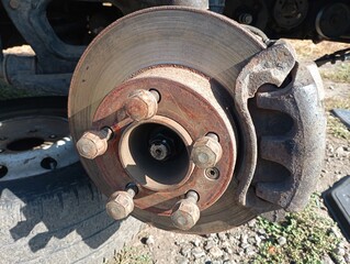 Brake disc and caliper with brake pads. Car suspension replacement and repair. Repair of automobile equipment and maintenance of the brake system.