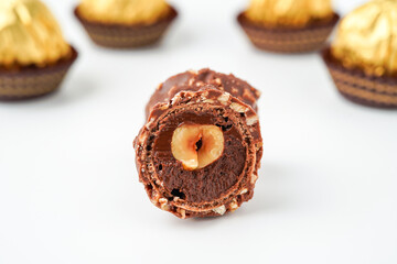 Sweet chocolate balls is made. Chocolate candy in gold wrapper on white background