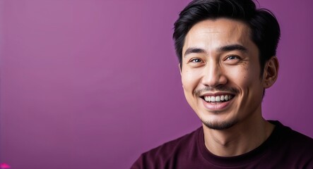 Fototapeta premium Young Asian man with almond shaped eyes smirking warm purple background