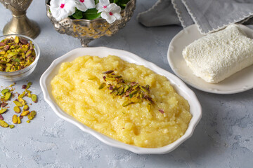Sweet yellow Turkish dessert cheese halva Hosmerim on the white plate in the kitchen.