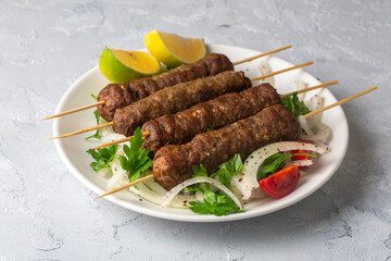 Grilled lula kebab on skewers served with fresh vegetables - Greek kebab or meatballs on a skewer