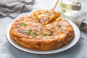 Spanish omelette with potatoes, typical spanish cuisine on gray concrete floor. Tortilla Espanola. Turkish name; Yumurtali patates