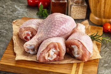 Raw uncooked chicken drumsticks over board