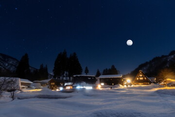 豪雪に覆われた山里の村に満月が輝く