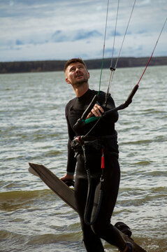 Middle aged man kite surfing, holding a bar in his hands.
