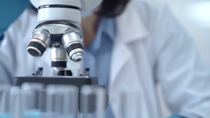 Scientist using microscope in laboratory. Close-up of a researcher's hands adjusting a modern microscope in a lab setting
