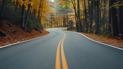 Fototapeta premium A winding road through a vibrant autumn forest, showcasing colorful foliage and serene nature.