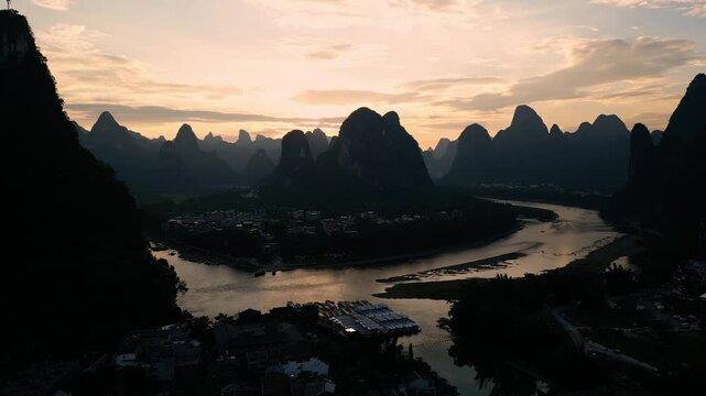 Xingping, China: Cinematic aerial drone footage of the sunset over the famous Li river in Xingping surrounded by dramatic karst landscape between Guilin and Yangshuo in China. 