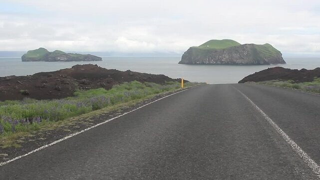Beautiful down road in the Westman Islands, Iceland. Two isolated and uninhabited islands in the background, Ellidaey and Bjarnarey.