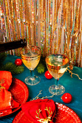 Modern Christmas table setting, red plates with napkins and two glasses of champagne on the festive table vertical photo copy space for text