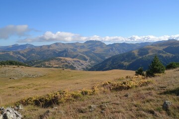 Expansive mountain landscape under a clear blue sky at golden hour in the wilderness