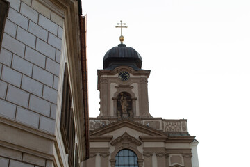 Obraz premium This is a picturesque church that features a prominent clock tower along with a beautiful cross positioned gracefully atop its structure