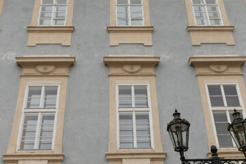 There is a large building that features numerous windows and has a charming lamp post positioned prominently in front of it