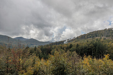 vista panoramica su di un ambiente naturale tra le colline e le montagne nella Slovenia occidentale, di giorno, sotto un cielo coperto, grigio e nuvoloso, a inizio autunno, pieno di vasti boschi