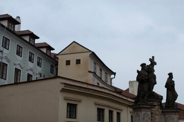A large building featuring various statues positioned in front of it against a dramatic cloudy sky on an overcast day