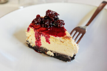 dettagli di una fetta di torta con crema di colore chiaro, insaporita con more e lamponi