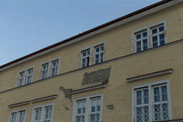 Obraz premium A beautifully painted yellow building stands prominently against a bright blue sky that fills the background with vibrant hues and warmth