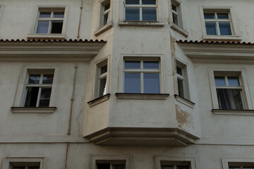 Fototapeta premium A striking white building that features a prominent bay window along with numerous additional windows adorning its facade, enhancing its beauty and appeal