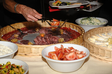 A delightful buffet featuring an assortment of charcuterie, fresh salads, and cheeses. Perfect for parties and gatherings, showcasing a vibrant and appetizing selection of gourmet foods ready for serv