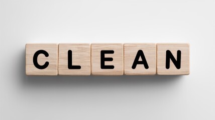 Overhead view of neatly arranged wooden blocks spelling out the word  CLEAN  on a plain white background conveying a sense of organization simplicity and minimalism