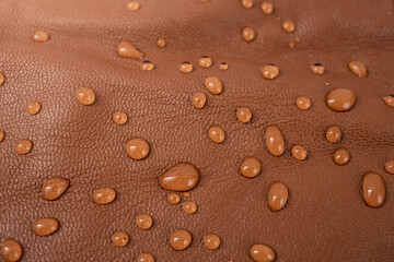 Water drops on red brown leather texture, top view, soft focus close up abstract pattern