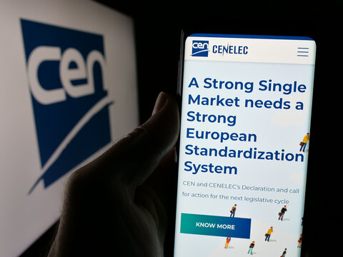 Stuttgart, Germany - 10-07-2024: Person holding cellphone with webpage of European Committee for Standardization (CEN) on screen with logo. Focus on center of phone display.